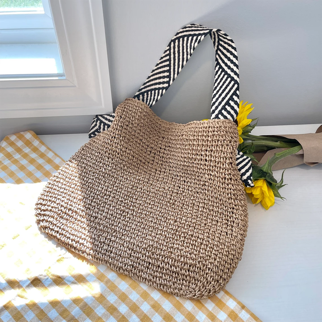 Natural Tan Open Weave Slouchy Tote With Striped Black White Fabric Shoulder Band, Snap Fastener Flap And Smooth Neutral Inner Lining