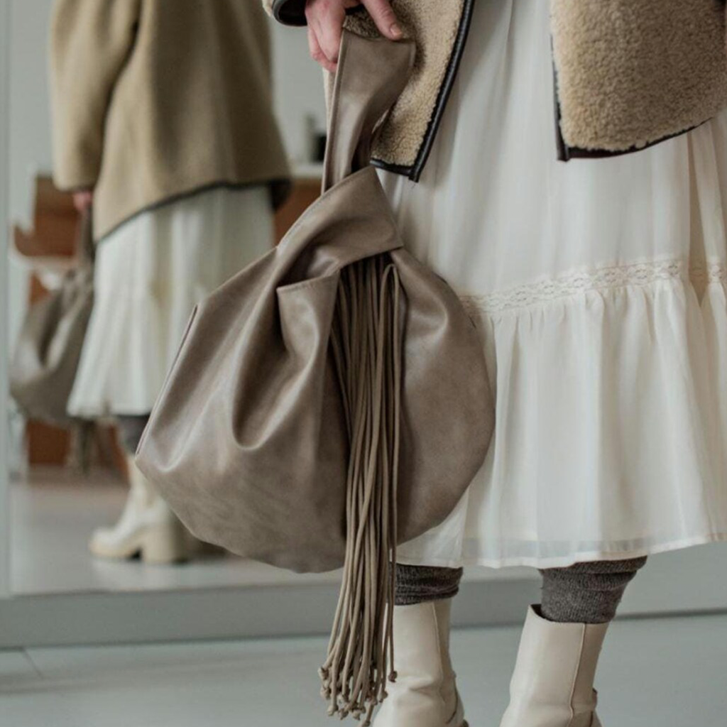 Muted Taupe Knotted Handle Slouchy Pouch With Cascading Matching Tassels, Hidden Zip Closure And Inner Divider Storage Slot Handbag