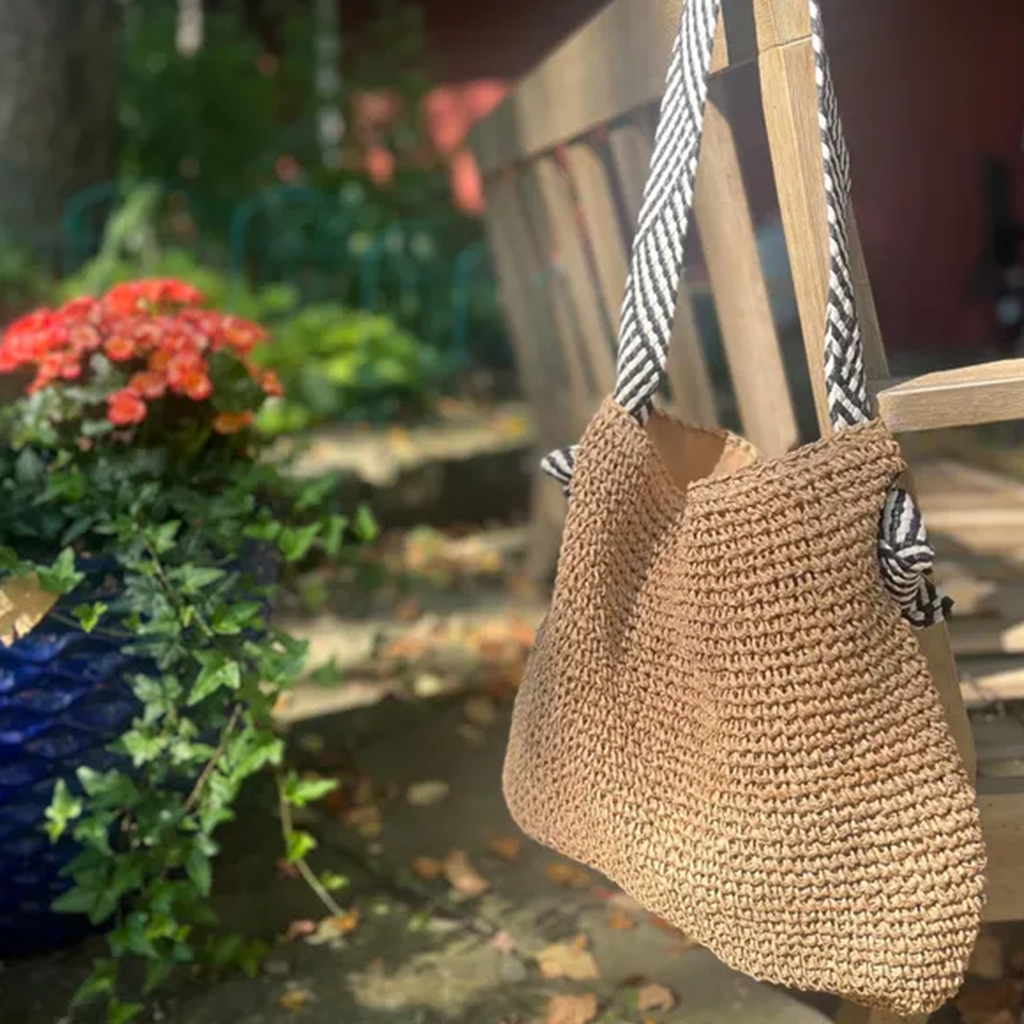 Natural Tan Open Weave Slouchy Tote With Striped Black White Fabric Shoulder Band, Snap Fastener Flap And Smooth Neutral Inner Lining