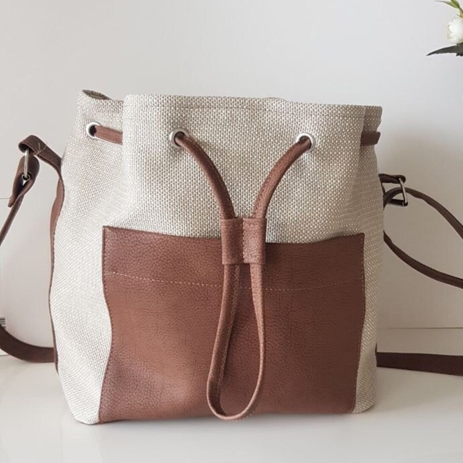Neutral Woven Two-Tone Bucket Tote Template With Contrast Brown Pebble Trim, Front Slip Compartment And Eyelet Drawstring Top Closure